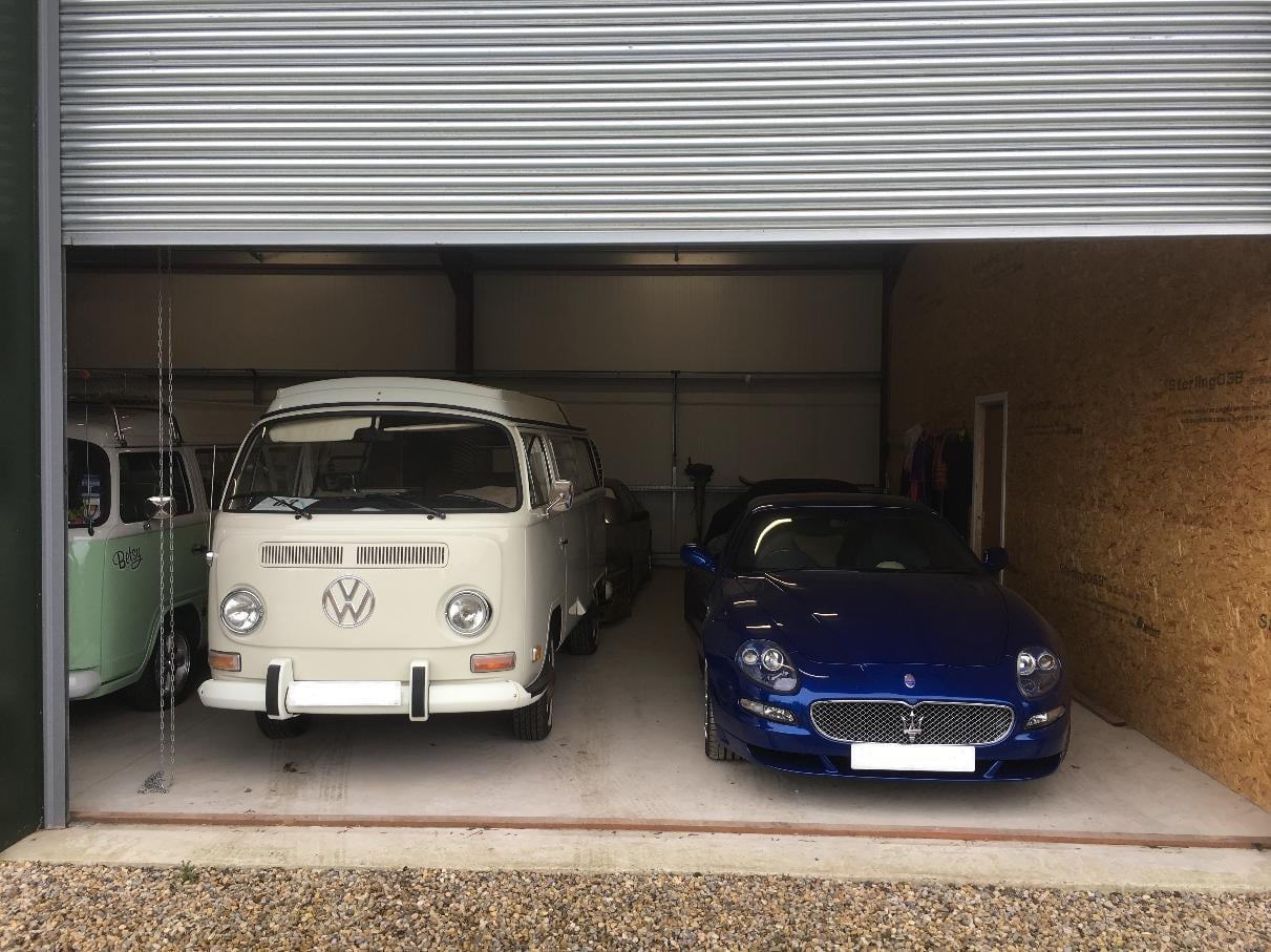 Inside our secure, clean vehicle storage facility showcasing a blue sports car and a classic camper van.